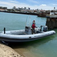 A rib from St. Francis Yacht Club measures the width of the harbor entrance.