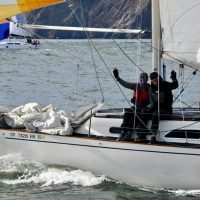Crew aboard John Rook's Ranger 33 Liquid Asset give a wave mid-ebb under the Golden Gate.