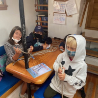 Campers-practicing-knot-tying-on-Matthew-Turner-with-our-favorite-magazine