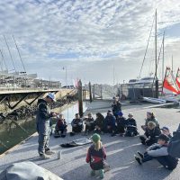 Tera sailors soak in knowledge from one of their coaches.