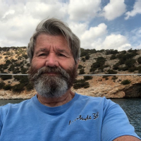 Self-portrait-of-Ron-Harben-last-week-in-a-secluded-cove-on-the-south-end-of-Naxos-Island-in-the-Greek-Cyclades-Rina-Cave-in-the-background.-