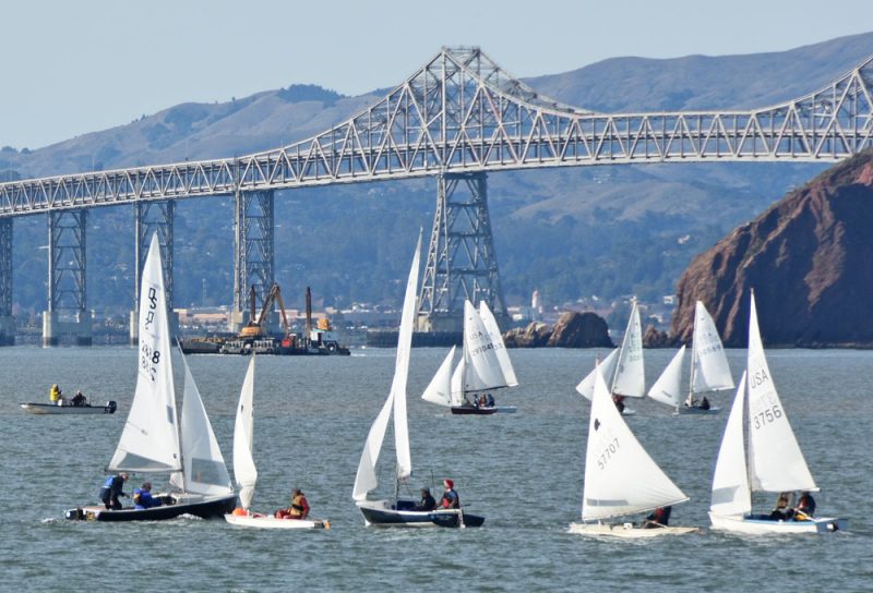 Small boats racing in front of the Richmond-San Rafael Bridge