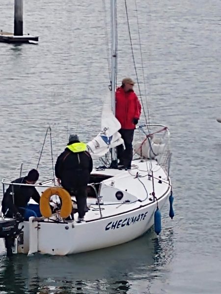 Student steers the boat away from the dock while instructor stands ready