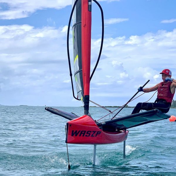 A sailor rides a foiling Waszp on hydrofoils.