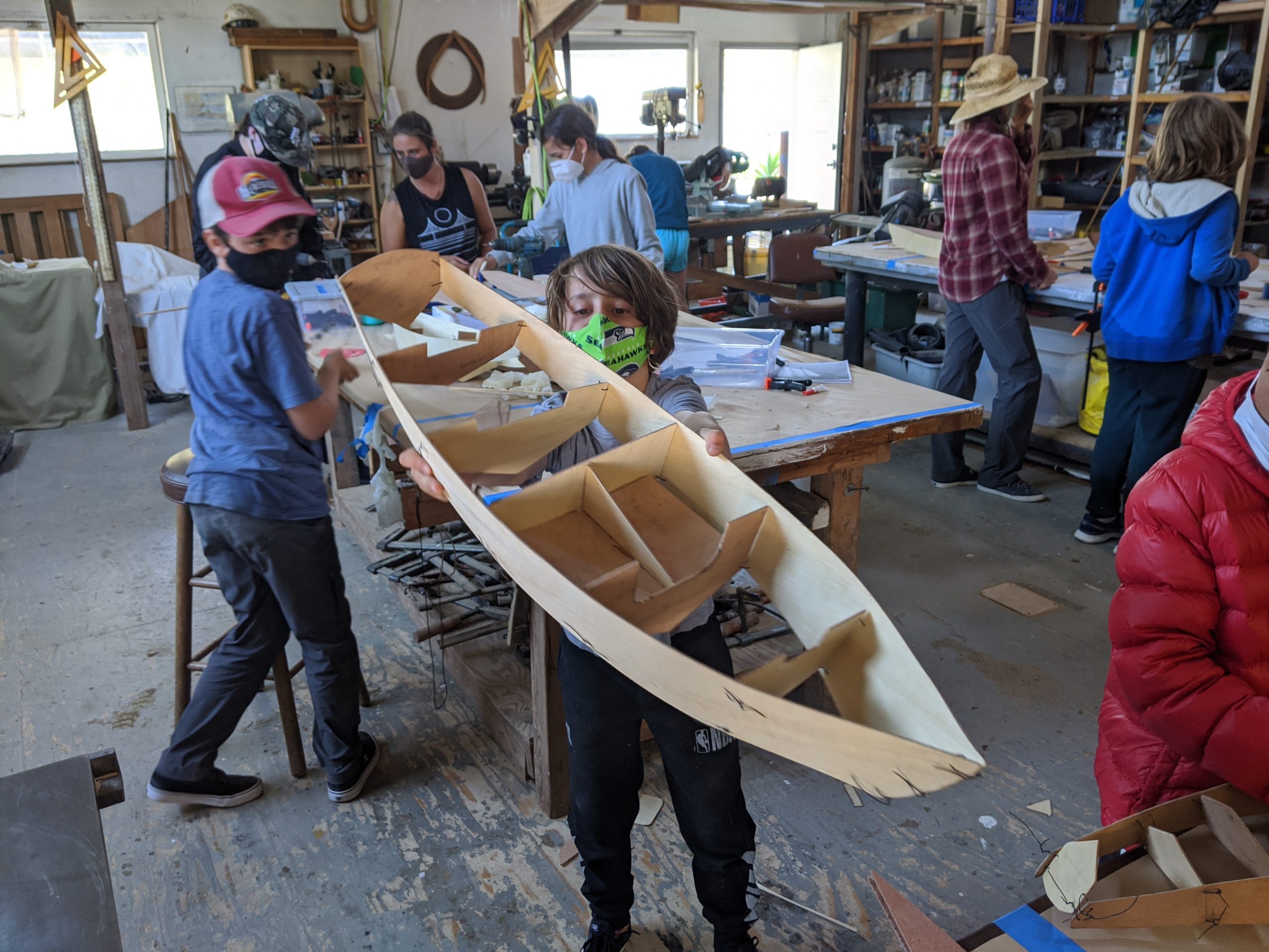 Masked youth holding model boat