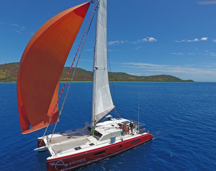 red catamaran with orange spinnaker