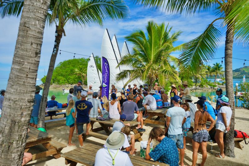 Crowd gathered under palm trees