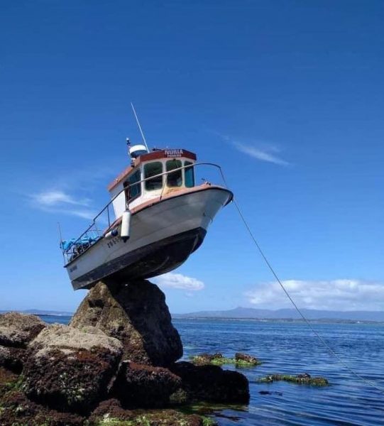 Anchored Boat High and dry on Rock