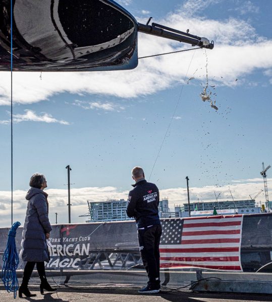 Using a line to hoist the bottle to the bowsprit