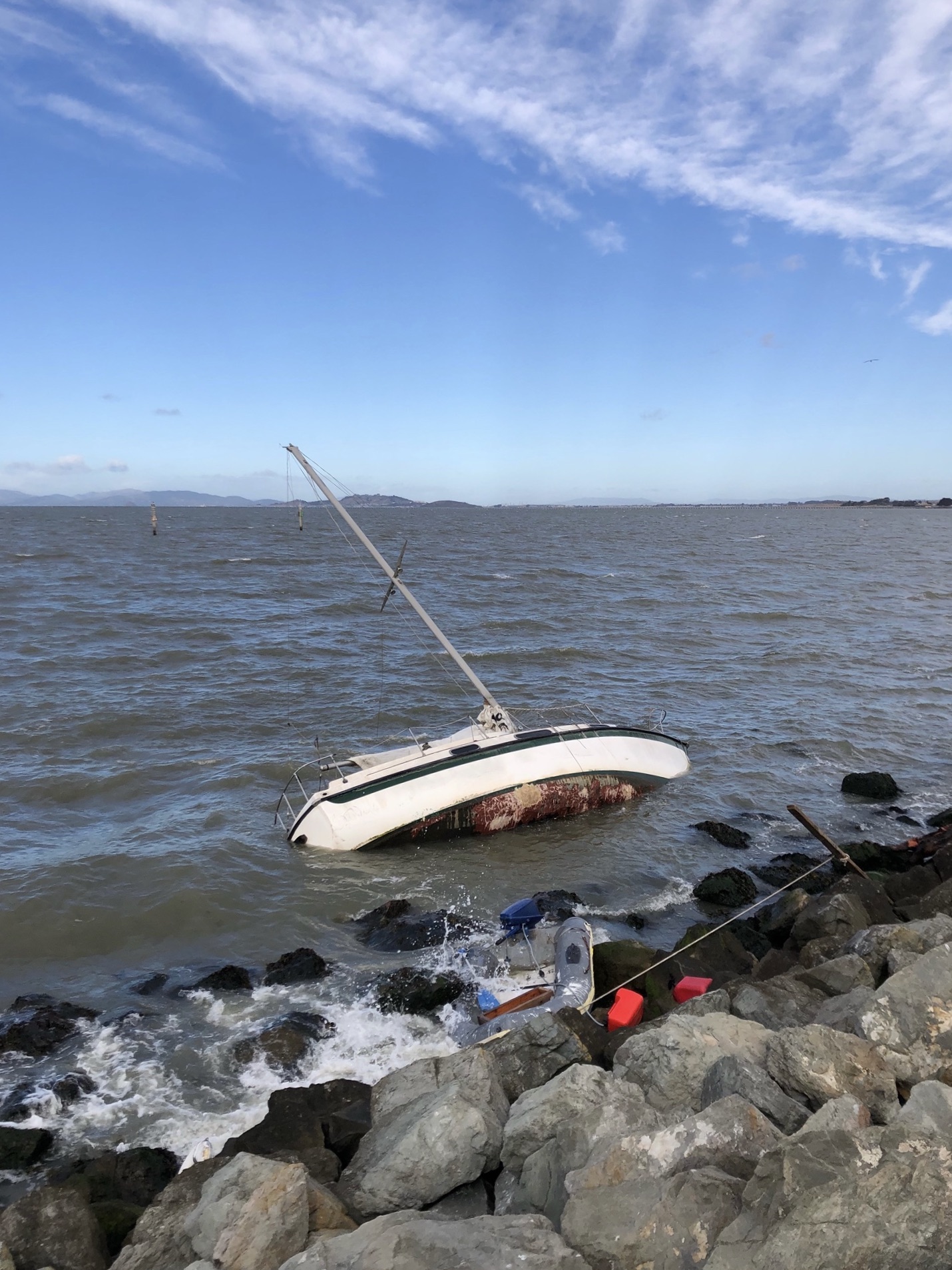 Sailboat and dinghy on the rocks