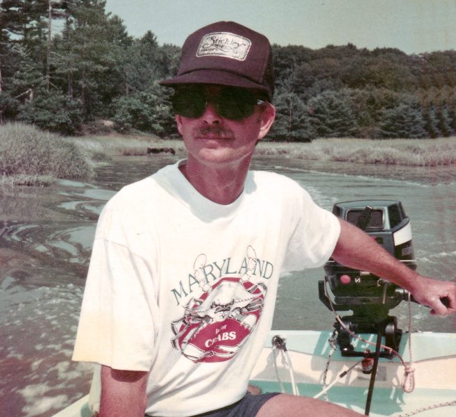 David wearing the shirt while motoring a dinghy