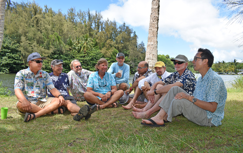 2021 skippers sitting on the grass in front of the river