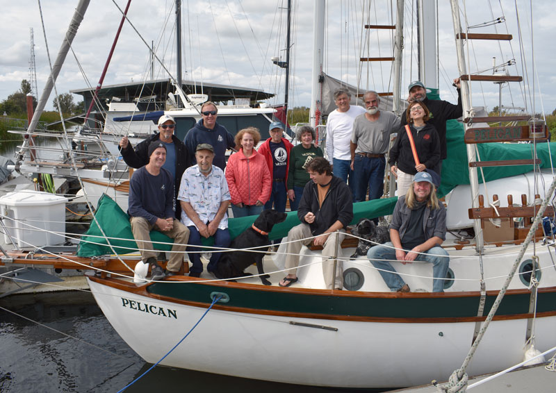 A lot of humans and two dogs on the bow of a Westsail 32.