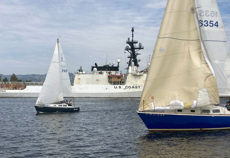 Boats racing in front of Coast Guard cutter