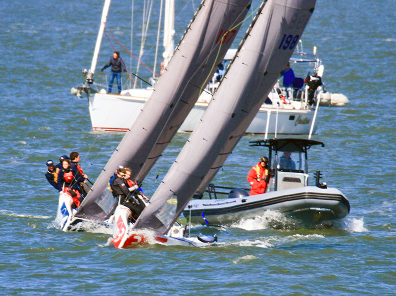Two RS21s with umpire boat and spectator sailboat