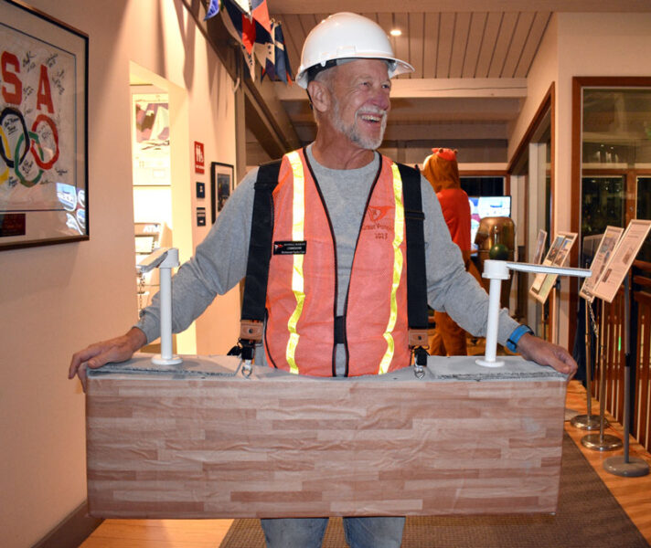 Man dressed as construction worker with two hoists.