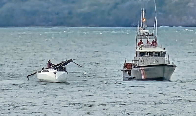 Dismasted sailboat with USCG cutter