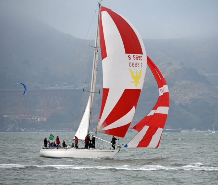 Typon flying a red and white striped blooper and spinnaker.