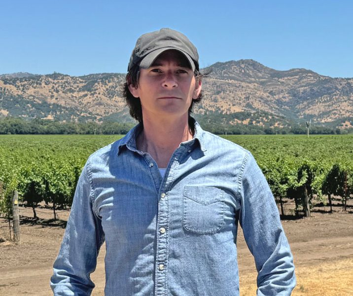 Christopher Rusin with a vineyard in the background.