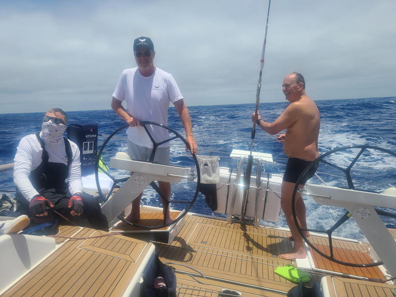 Barry Clark at the helm of Blackwing while Jeff Bunce gets a mid-Pacific bucket shower.