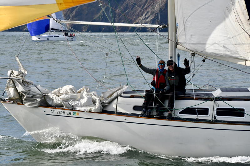 Crew aboard John Rook's Ranger 33 Liquid Asset give a wave mid-ebb under the Golden Gate. 