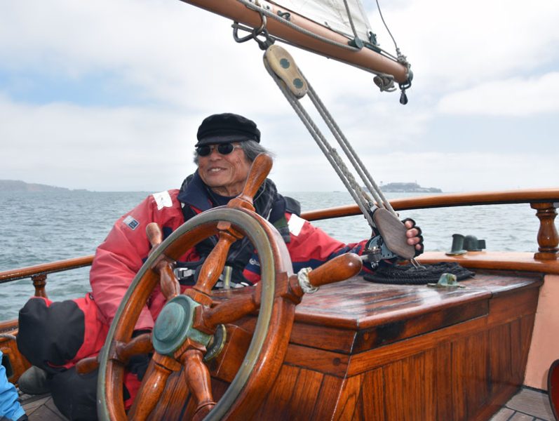 Skipper at the wheel of wooden classic