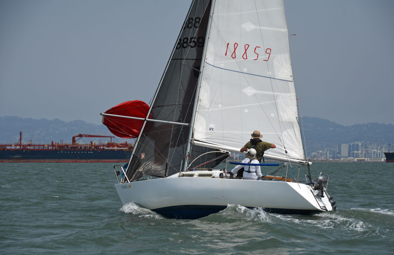 Doublehanded crew setting a red spinnaker