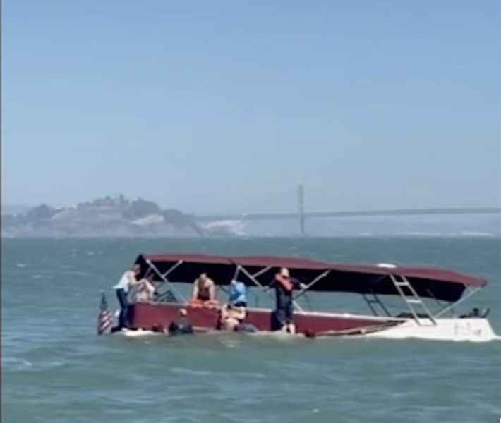 peopele clinging to boat