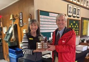 'Latitude 38' Publisher John Arndt delivers the Susie Wosser Trophy to its 2025 winner, Petra Gilmore. It is on display at Sequoia Yacht Club