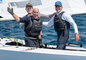 Paul Cayard, Ben Lamb and James Mayo celebrate winning the 2026 Etchells World Championship in San Diego.
